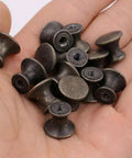10 Pcs Vintage Bronze Drawer Pull Handles Zinc Alloy Mini Metal Knobs held in a hand, showing compact size and bronze finish.