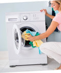 Person loading laundry into a washing machine with 8 Pack Anti Skid Heightening Pads For Washing Machines And Fridges visible at the base