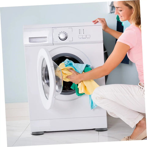 Person loading laundry into a washing machine with 8 Pack Anti Skid Heightening Pads For Washing Machines And Fridges visible at the base
