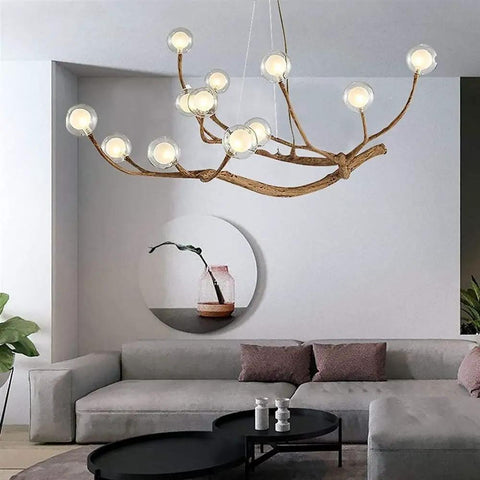 Modern Glass Bubble Chandelier With Sleek Wood Branch Accents, Rustic Industrial Flush Mount Pendant Light For Living Room, Adjustable Hanging Lamp above a sofa.