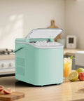 Countertop Ice Maker With Scoop, Basket And Handle, Portable Ice Machine on kitchen counter with fruit nearby, green
