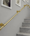 Solid As Rock Wall Stair Banister Handrail Complete Kit, 14 FT gold metal balustrade mounted on gray wall near staircase.