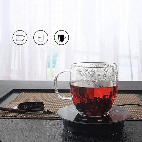Fast Acting USB Mug Warmer With Smart Adjustable Heat Control Keeps Your Morning Sip Piping Hot All Day Long Sleek Black Tempered Glass Platform with glass cup of tea.