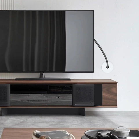 A TV setup showing a 4 Pack 1 Inch Wall Cable Pass Through Grommet in white on the wall for easy cable management and furniture hole cover.