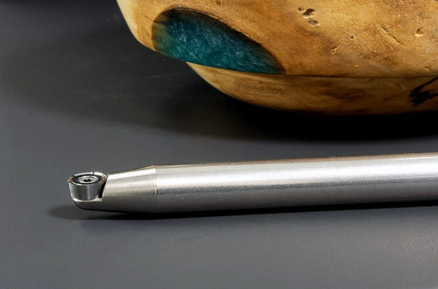 Carbide-tipped woodturning tool with 17-inch silver metal handle; side view with replaceable tip.