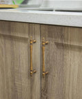 Six Pack 5 Inch Antique Brass Cabinet Pulls With Ornate Tapered Handles Decorative Finials And Sculpted Detailing shown installed on wooden cabinets.