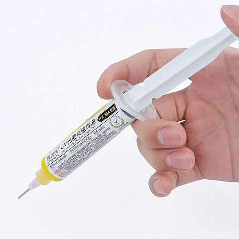 Yellow UV Soldering Paste Flux 10cc for PCB BGA use with syringe and push needle, held in hand for precise repairs.