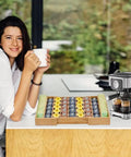 Woman enjoying coffee beside an expandable bamboo K Cup holder drawer organizer for coffee pods and tea bags