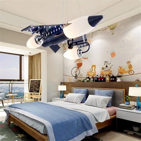 Airplane Shape Three Light Pendant For Kids Room Metal LED Suspension Fixture With Adjustable Chain Cartoon Aircraft Ceiling Light For Childrens Bedroom installed above bed.