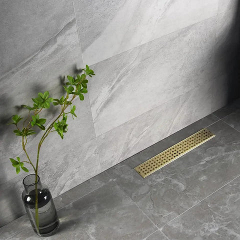 16 Inch Linear Shower Drain With Removable Cover Grid, Brushed Gold Stainless Steel SUS304, shown in bathroom floor