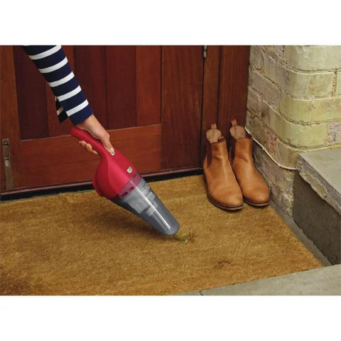 Person using Compact Lithium Hand Vacuum Kit With 2Ah Battery For Cars And Home Multi Surface Cleaning Lightweight Cordless Design on doormat.