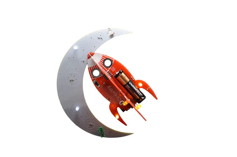 Spaceship Kit STEM Project Learn How To Solder Beginner Friendly Electronics Set With Tools Included For Teens 12 Plus And Adults To Build Real Circuits And Show Off Your Soldering Skills. red and gray spaceship-shaped solder kit with 9V battery