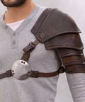 Single Shoulder Pauldron Armor In PU Leather Medieval Viking Gladiator Style With Rivet Detailing For Cosplay LARP And Stage Battles Badass Lightweight Rugged Bold Hero Look, worn by man in grey shirt