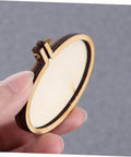 Hand holding a small elliptical wooden hoop from the Five Piece Mini Wood Embroidery Hoops Set With Screws For Cross Stitch And DIY Needlework.