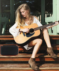 Woman playing guitar next to Durable Oxford Microphone Case For JBL Wireless Two Mic System Grab And Go Mic Storage Portable Box Color A.