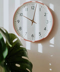 Modern wall clock with Wooden Clock Hands Replacement Kit 5.11 Inch Clock Pointer Plates, white face, next to plant