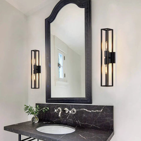 Dual Bulb Metal Frame Wall Sconces With Symmetrical Square Design in black finish next to a bathroom mirror