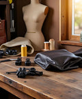 12 Piece Black Zipper Repair Kit With Removable Sliders on wooden table with sewing materials and mannequin in background