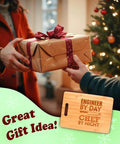 Engineer By Day Chef By Night Wood Cutting Board under Christmas tree next to gift, holiday theme.