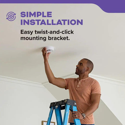 Man installing Ten Year Battery Hardwired Smoke And Carbon Monoxide Detector With Interconnect For Home Safety LED Indicators