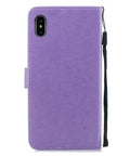 Back view of a purple phone case with a wrist strap, showing card slot and camera cutout.