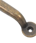 Close-up of a rustic bronze cabinet drawer pull in vintage iron for modern home furniture, showing smooth finish and durable construction.
