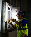 Electrician using Rechargeable Wide Beam Headlamp With Strap And 575 Lumens Five Lighting Modes All Day Runtime Direct Focus And Hard Hat Compatibility For Work And Outdoor Adventures while examining a circuit breaker panel.