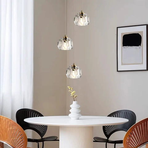Modern Raindrop Pendant Lights Set Of 3, Brass Round Hanging Lamps with Clear Crystal Prisms, over dining table.