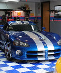 Blue car parked on interlocking garage floor tiles diamond pattern non slip heavy duty copolymer 12x12 inch modular tiles in garage.