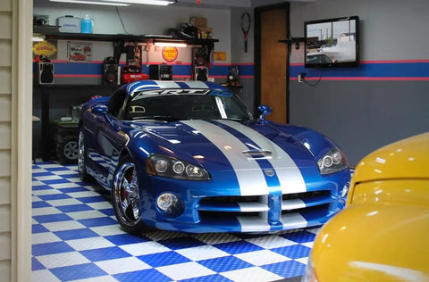 Blue car parked on interlocking garage floor tiles diamond pattern non slip heavy duty copolymer 12x12 inch modular tiles in garage.