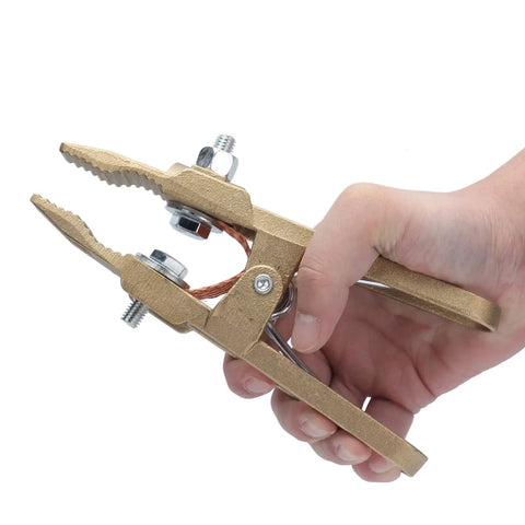 Heavy Duty Brass Welding Ground Clamp For Stick Mig Tigs And Cutting Tasks With Secure Locking Set Screws For Solid Earth Wire Connection In Professional Shop Settings, held in hand.