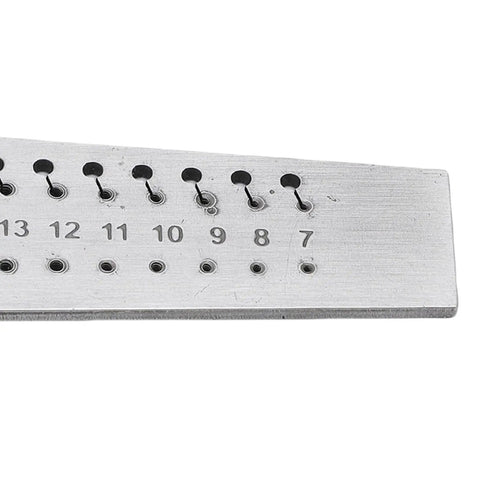 Close-up of a 36 Hole Watchmakers Tap And Die Set Stainless Steel Micro Tool Kit on a durable steel board