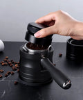 Hand using 54mm Espresso Portafilter Holder And Tamper Stand With Non Slip Base For Aluminum Alloy 54mm Espresso Machines Black