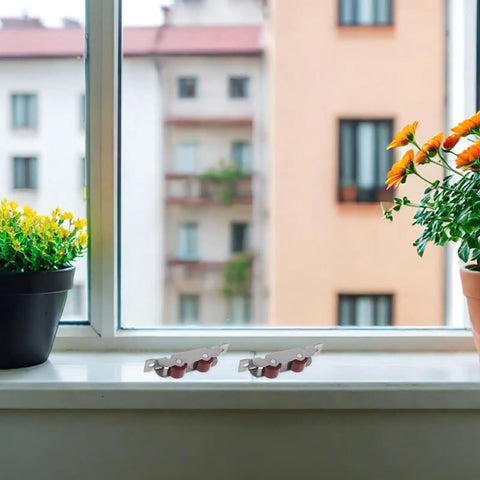 High Load Stainless Steel Sliding Glass Door Rollers Four Pack Double Wheel Track Glides on a windowsill next to potted plants.