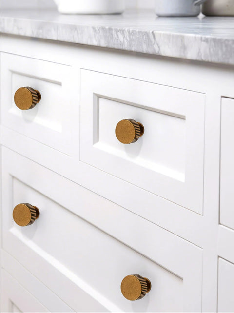 Close-up of Antique Brass Kitchen Cabinet Knobs 10 Pack Zinc Drawer Pulls installed on white cabinets