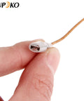 Close-up of Aupoko thermocouple heater connector on beige insulated wire; silver cylindrical tip with flat terminals.