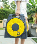 Heavy Duty Retractable Garden Hose Reel Cart With 82 Foot Hose And Multifunction Spray Nozzle held by a person outdoors.