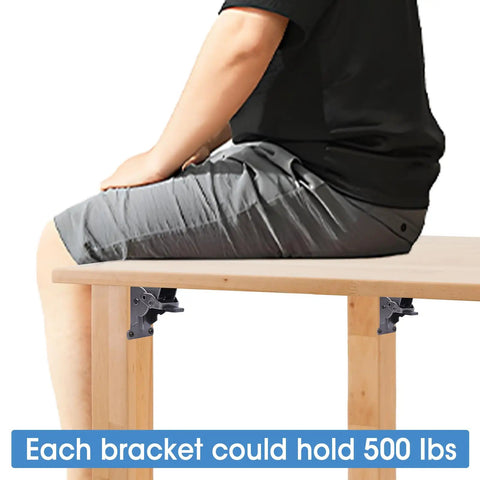 Person sitting on a wooden table using 12 Pack Heavy Duty Self Locking Hinges For Folding Tables Rock Solid Steel Furniture Brackets.