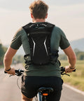 Cyclist wearing Ultra Light Hydration Vest With Built In Water Reservoir For Runners And Adventurers Lightweight Hydration Backpack.