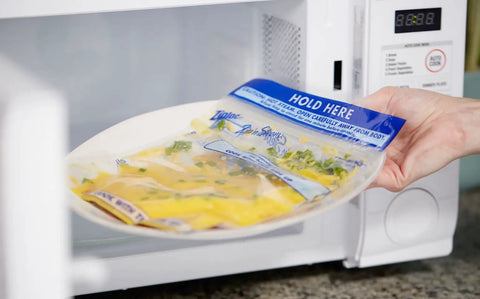 Hand placing Zip N Steam Microwave Safe Food Storage Bags For Meal Prep, Perfect For Steaming Vegetables, Fish, And Chicken, No Cleanup, 10 Count, Healthy Meals In Minutes With Easy Microwave Cooking in microwave