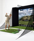 Golfers using the All In One Golf Simulator Studio Pro Package with launch monitor, rugged case, enclosure, in a home setup.