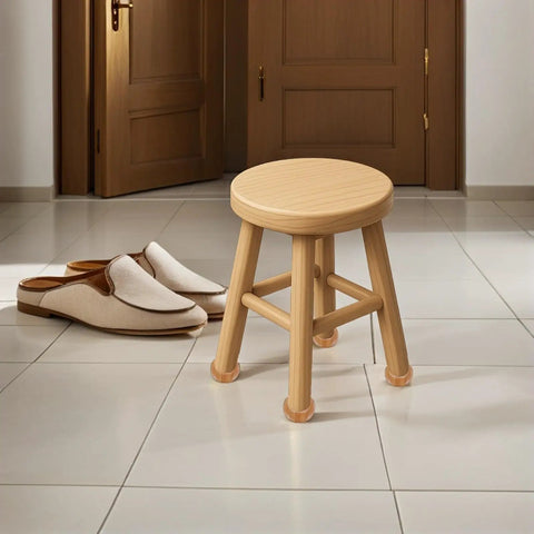 Round wooden stool on tiled floor, door, and slippers in the background