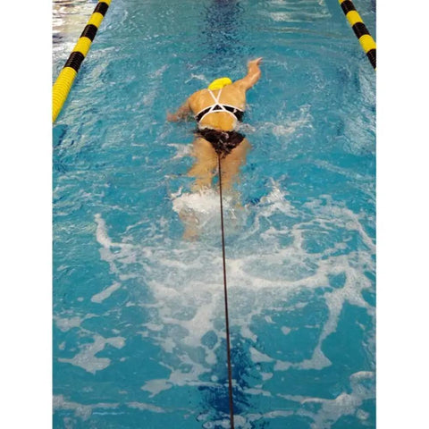 Swimmer using Long Belt Slider for In Water Resistance Training in Green, performing resisted swim-outs in pool.