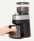 Professional Flat Burr Coffee Grinder With 30 Precision Settings For French Press Drip Coffee And Espresso Anti Static Housing And Six Point Five Ounce Hopper Black with coffee beans in reservoir and ground coffee container.