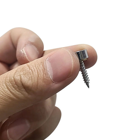 Hand holding polished stainless steel mirror screw cap with screw, 10mm decorative cover for mirrors, tea tables, and glass furniture