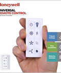 Hand holding Honeywell universal remote for Carnegie 52 Inch Industrial Style Indoor Led Ceiling Fan With Light Remote Control