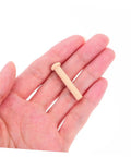 Miniature Wooden T Nails For Crafts And Woodworking With Ergonomic T Head Design shown in hand, emphasizing size and beige color.