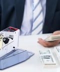 Portable Money Counter Machine Mini Bill Counter For Fast Cash Counting on office desk, man holding bills, gray device