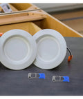 100 Pcs Spring Clips Snap Downlight Mounts For Garage Fixtures LED Strip Light Accessories with recessed lights on table.