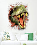 3D T-Rex Dinosaur Wall Sticker bursting through cracked wall, above a white couch with green cushions in a living room.
